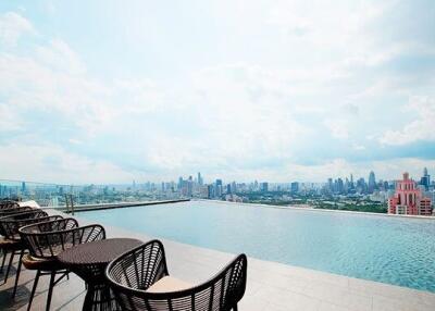 Rooftop infinity pool with city skyline view and lounge chairs