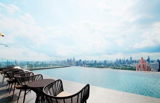 Rooftop infinity pool with city skyline view and lounge chairs