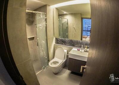 Modern bathroom interior with glass shower and marble accents