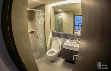 Modern bathroom interior with glass shower and marble accents