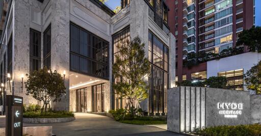 Modern building entrance at dusk with illuminated facade