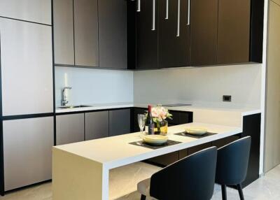 Modern kitchen with a sleek design, equipped with built-in cabinets and a central island