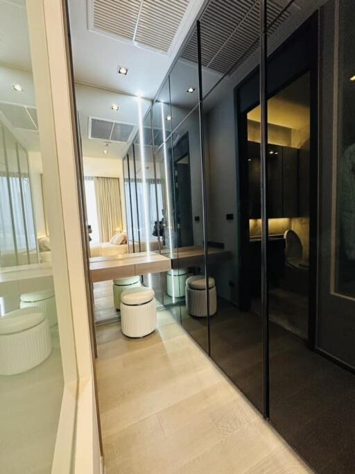 Modern bedroom with en-suite bathroom and reflective glass wardrobe