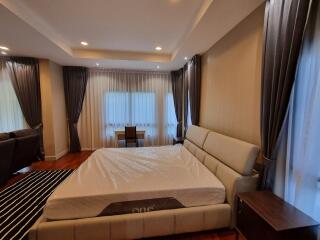 Spacious master bedroom with large bed and modern furnishings