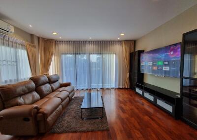 Spacious living room with modern furniture and large television