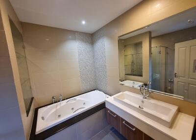 Spacious bathroom with modern facilities, including a jacuzzi tub, dual sink vanity, and separate shower area