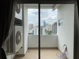 Compact balcony with air conditioning units and a view of the cityscape