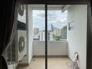 Compact balcony with air conditioning units and a view of the cityscape