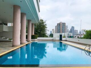 Swimming pool area in a modern residential building with city skyline