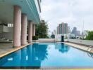 Swimming pool area in a modern residential building with city skyline