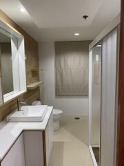 Modern bathroom with white fixtures and wooden accents