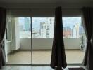 Bright bedroom with large windows overlooking the cityscape