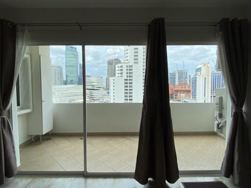 Bright bedroom with large windows overlooking the cityscape