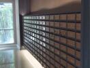 Modern mailroom in residential building with secured mailboxes and natural light