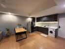 Modern kitchen with dining area, wooden flooring, and appliances