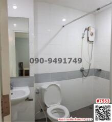 Modern white tiled bathroom with toilet and shower