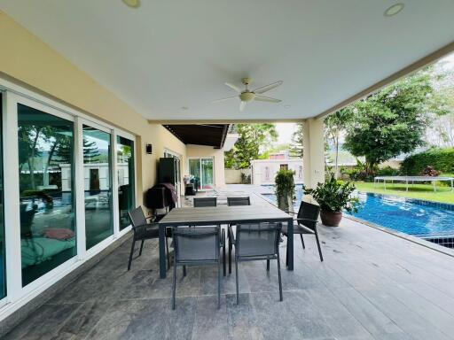 Spacious patio area with dining table and pool view