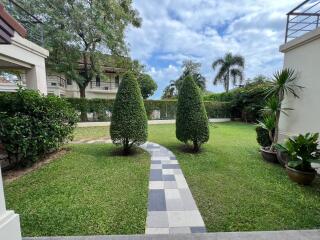 Lush green garden with walking path and manicured bushes