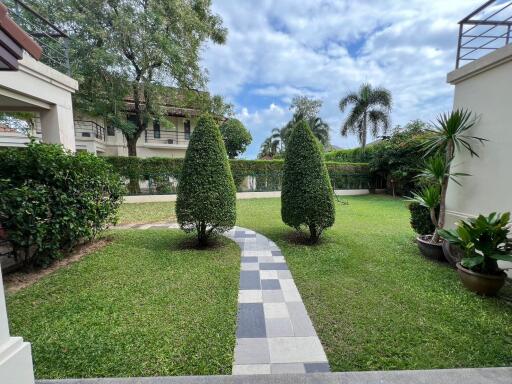 Lush green garden with walking path and manicured bushes