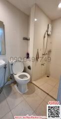 Compact bathroom with white fixtures, including toilet and shower area