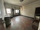 Spacious unfurnished room with parquet flooring, multiple windows, and in need of renovation