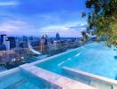 Rooftop swimming pool with city skyline view at dusk