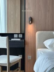 Modern bedroom detail showing part of the bed, nightstand, and a chair