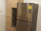Modern stainless steel refrigerator next to wooden kitchen cabinetry