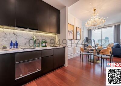 Modern kitchen with marble countertops and an adjacent dining area with a crystal chandelier