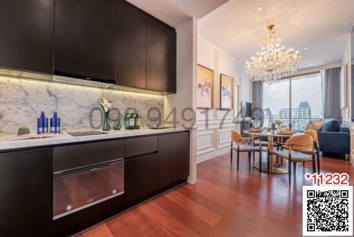 Modern kitchen with marble countertops and an adjacent dining area with a crystal chandelier