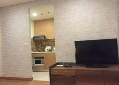 Modern living room interior with white brick wall and built-in kitchenette