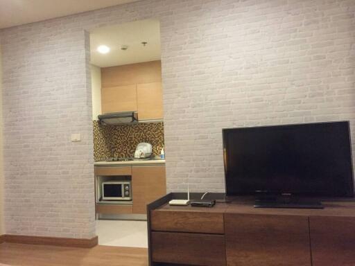 Modern living room interior with white brick wall and built-in kitchenette