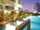 Luxurious building exterior with illuminated swimming pool at twilight