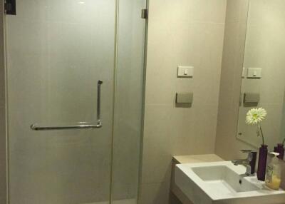 Modern bathroom with glass shower enclosure and white basin