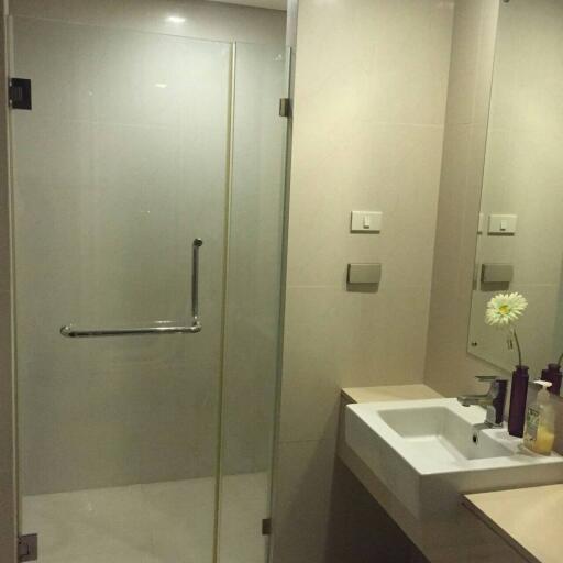 Modern bathroom with glass shower enclosure and white basin