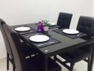 Modern dining room with a black table set for four