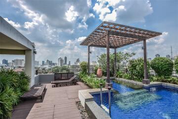 Luxurious rooftop terrace with swimming pool, lounge area, and city skyline view
