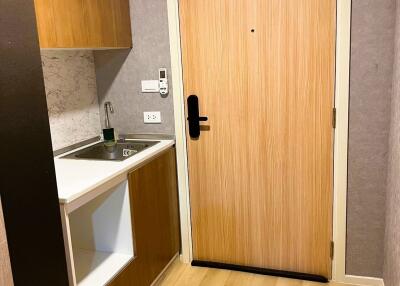 Compact kitchenette with wooden cabinets and a laminate flooring