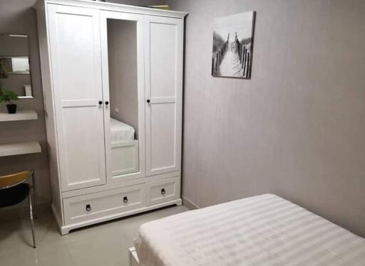 Cozy bedroom with white wardrobe and comfortable bed