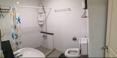 Compact bathroom with shower and bathtub combination, a toilet, and white walls