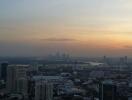 Aerial view of a cityscape during sunset with buildings and waterfront