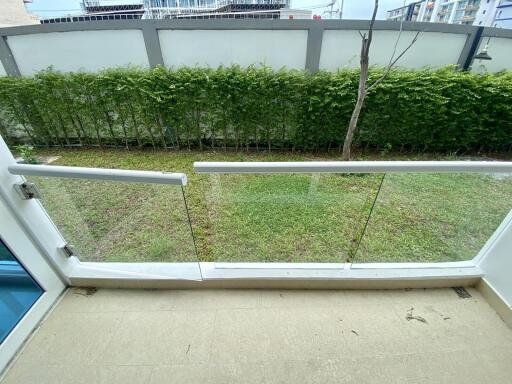 Compact balcony overlooking a green hedge and grassy area