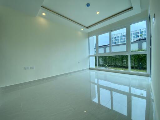 Spacious and bright empty living room with large windows and glossy floor
