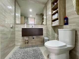 Modern bathroom interior with wall-mounted sink, toilet, and tiled floors
