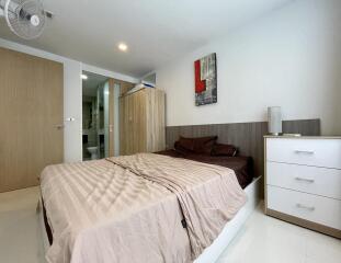 Modern bedroom interior with king-size bed and wooden furniture