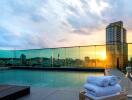 Rooftop swimming pool with city skyline at sunset