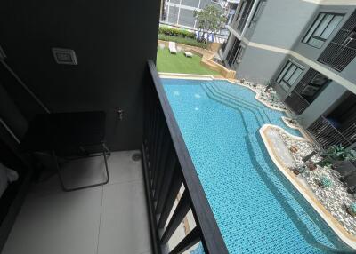 View from a balcony overlooking a swimming pool and courtyard in a residential complex