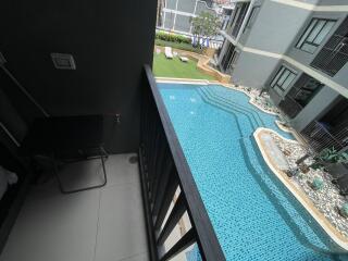 View from a balcony overlooking a swimming pool and courtyard in a residential complex