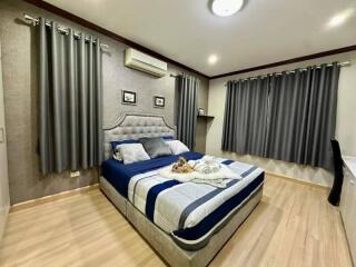 Elegantly designed modern bedroom with king-sized bed and air conditioning