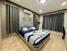 Elegantly designed modern bedroom with king-sized bed and air conditioning